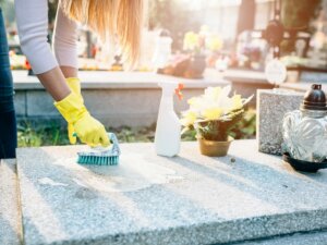 grabstein_reinigen_frau_grabplatte_friedhof